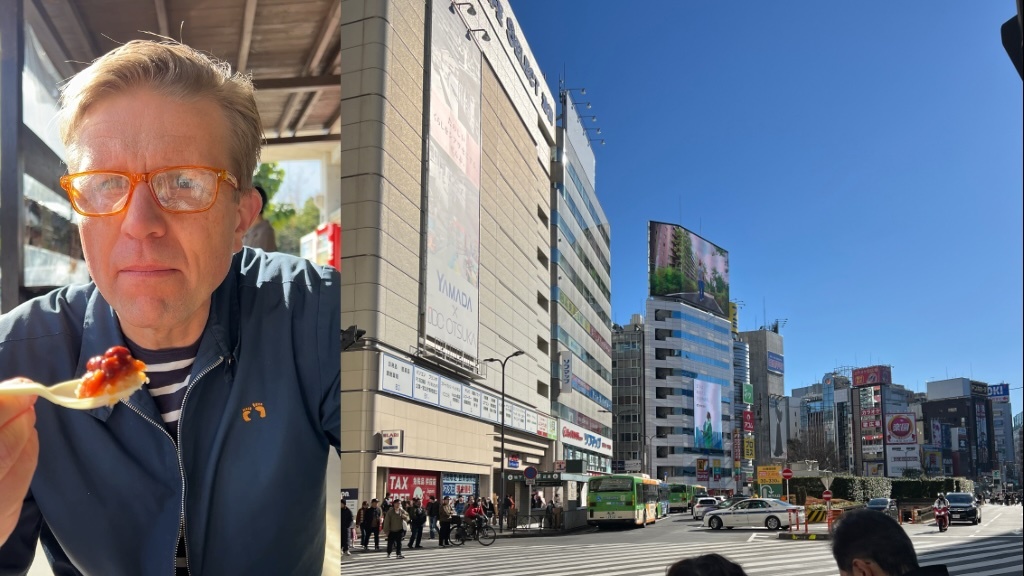 En man med orange glasögon och en blå jacka äter mat till vänster, medan en solig stadsmiljö med höga byggnader, reklamskyltar och en trafikerad gata syns till höger.