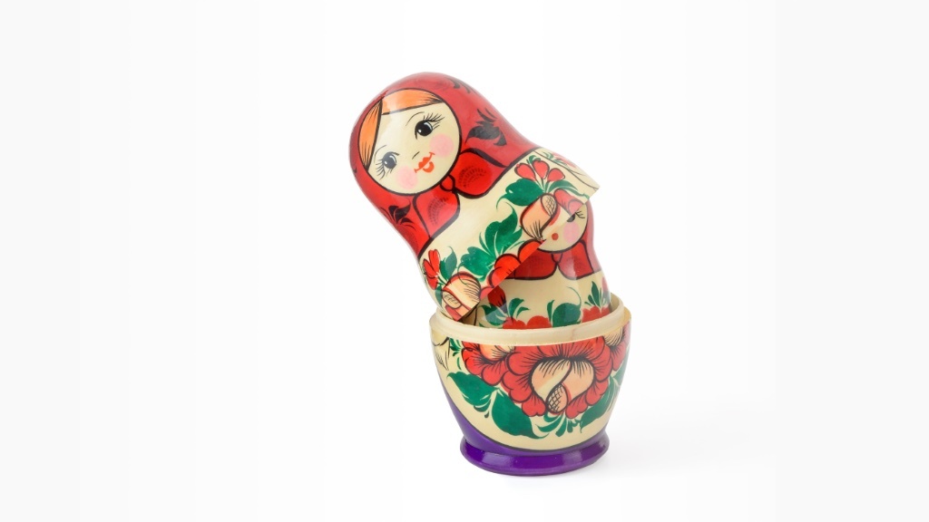 A partially opened matryoshka doll with a smaller doll inside is displayed against a white background.